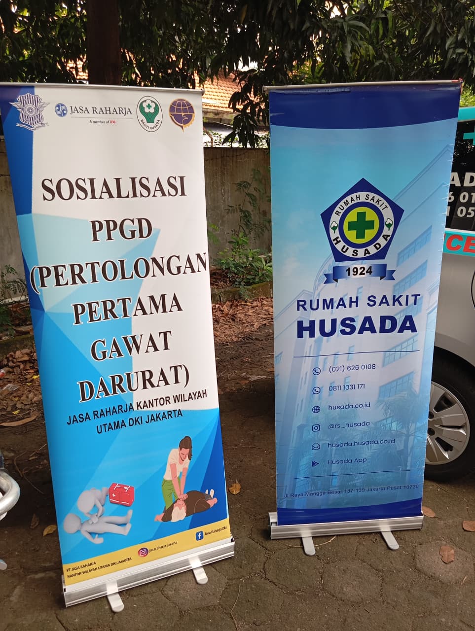 Spanduk Sosialisasi PPGD (Pertolongan Pertama Gawat Darurat) hasil kolaborasi antara Jasa Raharja Kantor Wilayah Utama DKI Jakarta dan Rumah Sakit Husada menjadi simbol komitmen bersama dalam meningkatkan keselamatan lalu lintas.